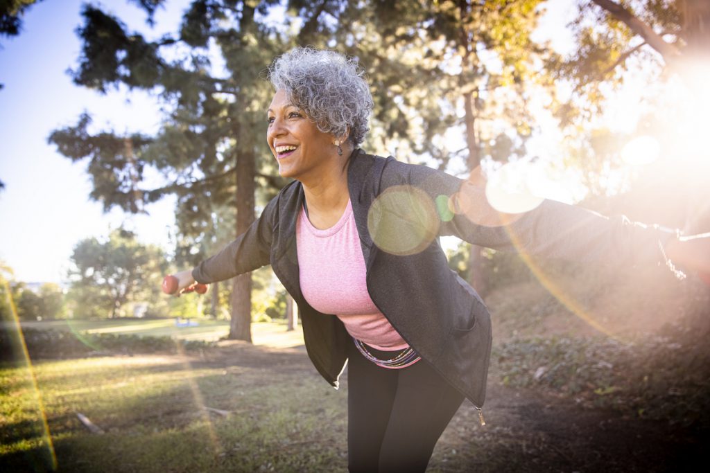 smiling senior black woman exercising outdoors for a story on daily exercises for older adults