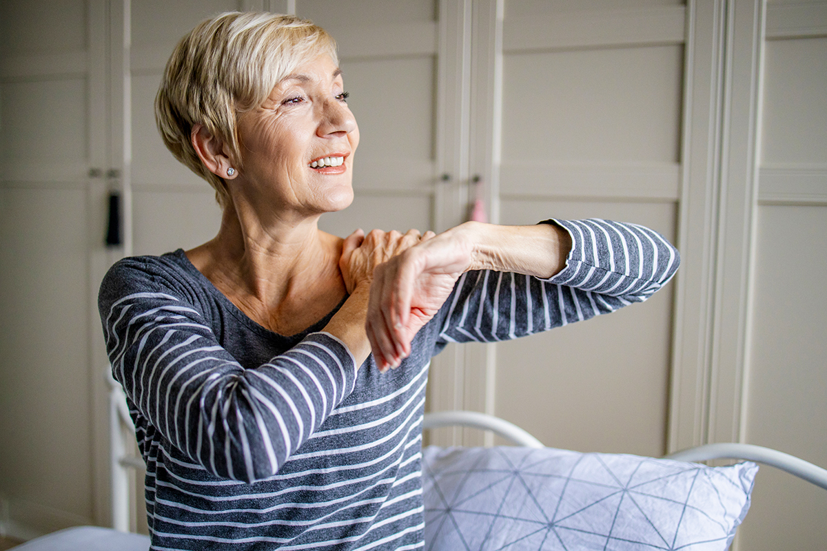 Mature woman stretching her shoulder