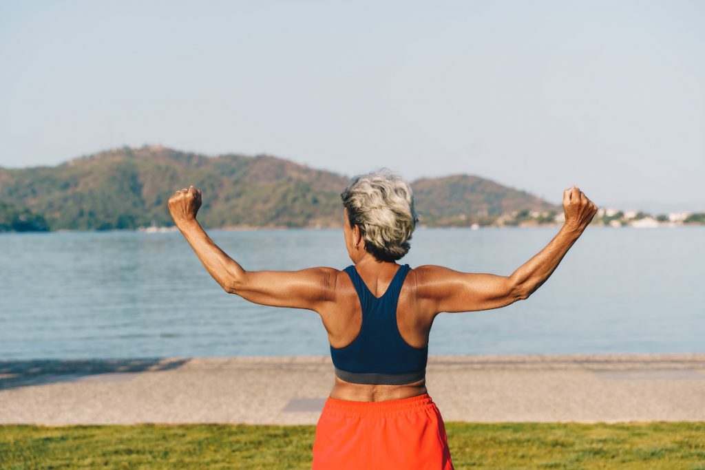 Senior woman exercising outdoors for a story on back strength exercises for seniors