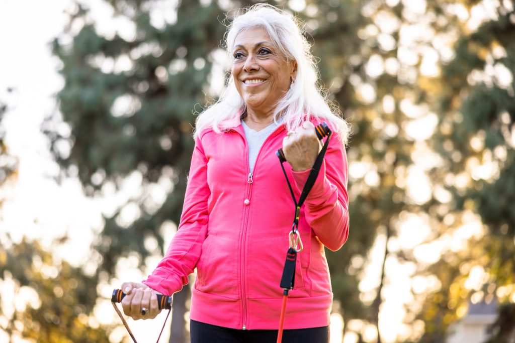 A senior woman training her upper body with resistance bands